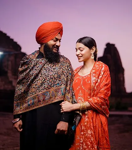 As twilight sets in, Preet and Gurleen share a look against the backdrop of ancient temple silhouettes. The purple sky and their traditional outfits create a magical and romantic atmosphere.