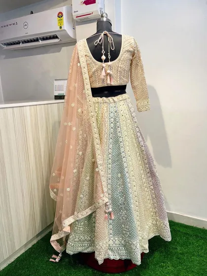 I love the delicate look of this pastel rainbow lehenga. It's covered in intricate chikankari and mirror work, making it a sophisticated and elegant rental option for a day wedding or engagement.