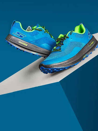 Dynamic studio shot of Skechers Go Run athletic shoes, using bold colors and angular composition to create a sense of energy and motion. This style of footwear photography is perfect for advertising campaigns that need to pop.