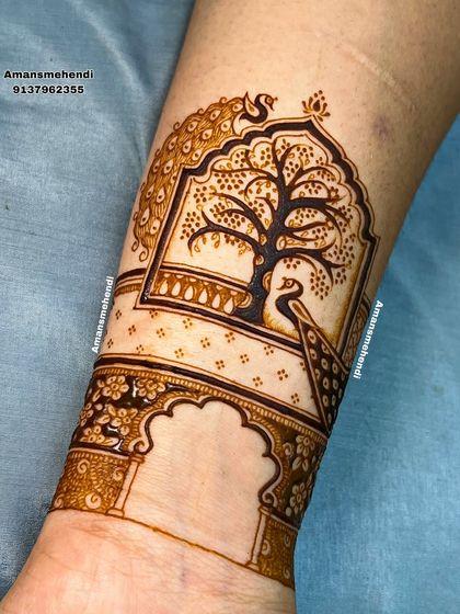 A close-up of a beautiful arm band featuring a peacock looking at a tree of life inside a jharokha. The detail in the peacock's feathers is a highlight of this piece.