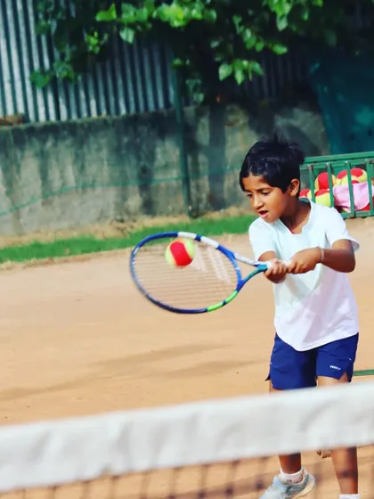 A close-up of a junior player making contact with the ball on his forehand.