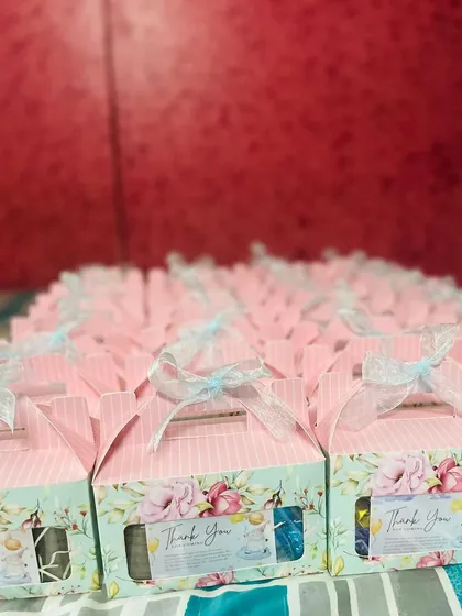 Here is a look at a bulk order of baby shower return favors. Each box is beautifully designed with a floral print and a "Thank You" note, ready to be filled with treats for guests.