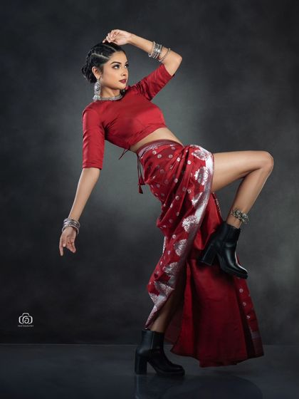A dynamic, full-body pose that captures the energy of this fusion fashion concept. The combination of a traditional saree with combat boots creates a unique and memorable image.