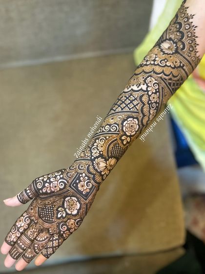 Full arm bridal henna for Zeba, featuring a mix of geometric shapes, floral motifs, and delicate line work.