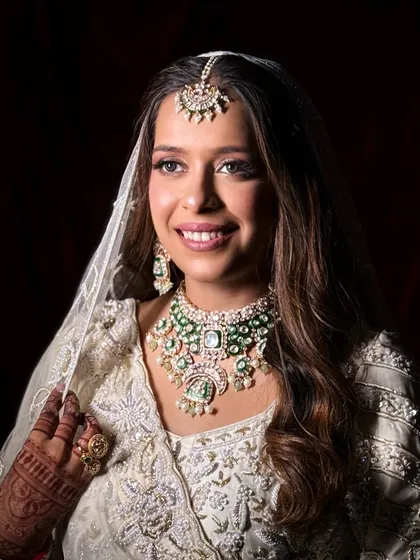 A classic bridal portrait. The sheer dupatta frames her face beautifully, and the makeup looks soft and ethereal.