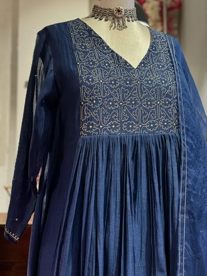 A detailed view of the navy blue anarkali, showcasing the intricate silver embroidery on the yoke and the sheer, lightweight dupatta.