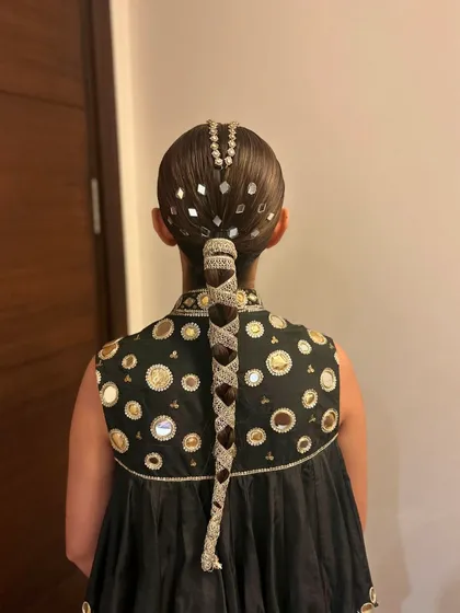 For the bride who loves to shine. This sleek braid is decorated with gota patti and mirror work, perfectly matching the embellishments on her outfit.
