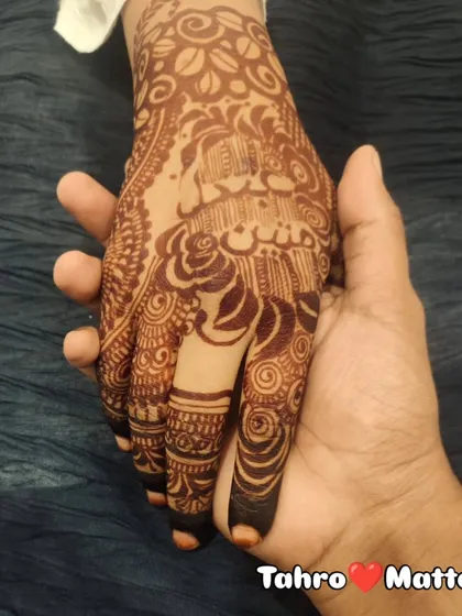"Your name on my hands makes my mehendi complete!" This photo captures the beautiful dark stain of a design that features the couple's names, 'Tahro' and 'Matto'.