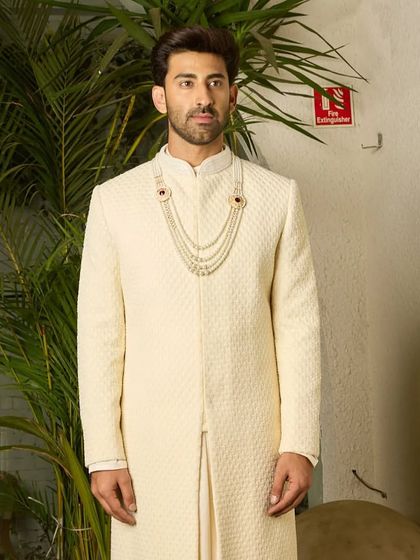 The textured off-white sherwani stands as a testament to timeless romance. Its precision tailoring and luxurious feel are designed for the groom who wants to make a lasting impression.
