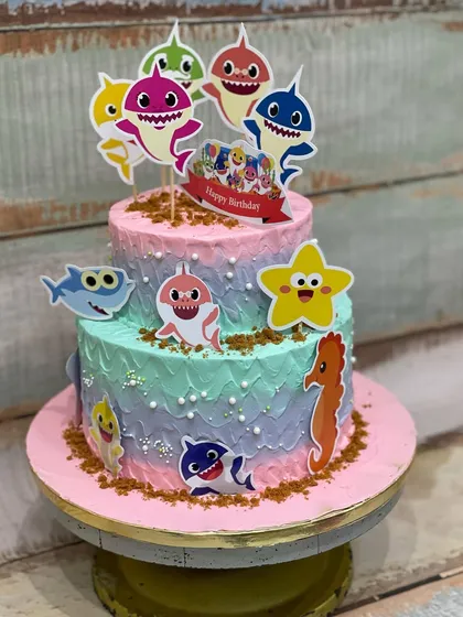 This two-tiered Baby Shark cake was so much fun to make for a little one's birthday. The colorful buttercream and cute character toppers brought the underwater theme to life.