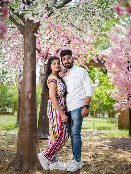 A beautiful portrait under blooming cherry blossom trees. This classic romantic setting is perfect for creating soft and dreamy pre-wedding photos.