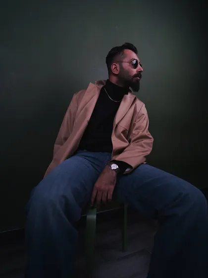 A profile shot that highlights the cut of the jacket and the overall silhouette. This is a classic pose for showcasing men's apparel, watches, or eyewear.