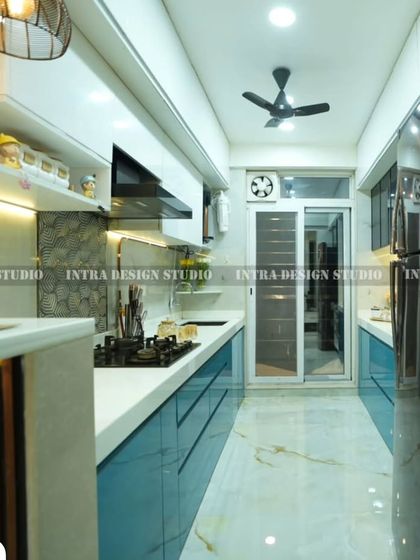 A full-length view of the blue parallel kitchen, showing how the layout maximizes a narrow space. The design ensures an efficient workflow between the stove, sink, and prep areas.