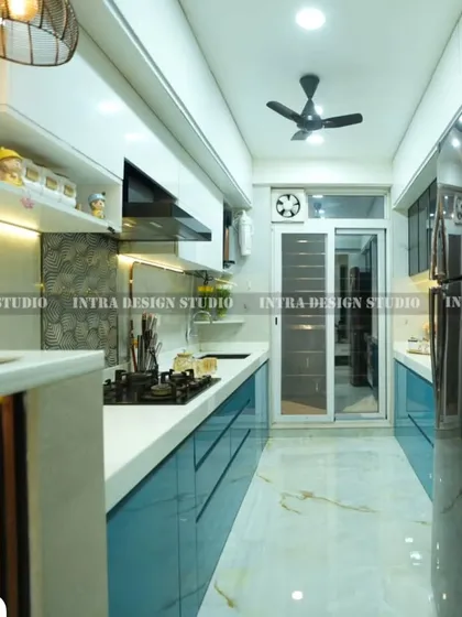 A full-length view of the blue parallel kitchen, showing how the layout maximizes a narrow space. The design ensures an efficient workflow between the stove, sink, and prep areas.