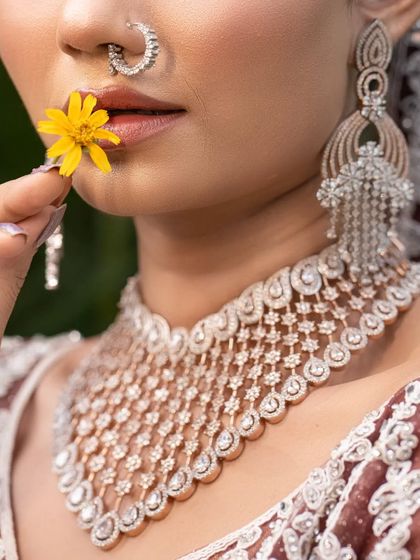 A close-up detail shot focusing on the bride's stunning diamond necklace and nath. This type of shot is perfect for highlighting bridal jewelry.