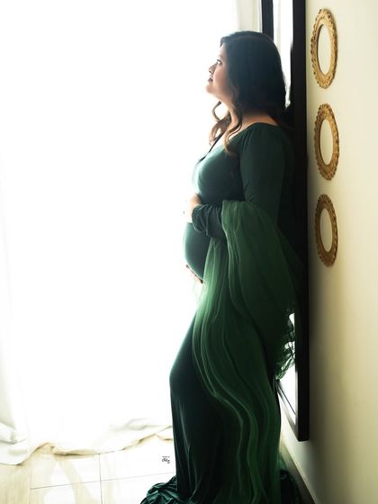 A silhouette against the bright window. This high-contrast, artistic shot beautifully outlines the shape of her pregnancy.