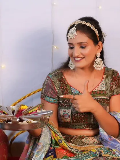 A playful shot of the bride with a platter of mehendi cones, her makeup perfect for the festive occasion.