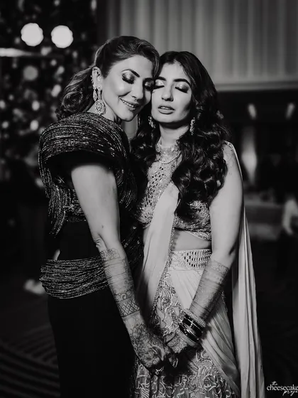 A quiet, emotional moment between the bride and her mother or mother-in-law during the reception.