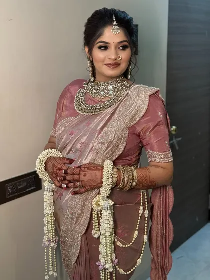 A portrait of the bride in her pastel pink saree, looking serene and happy.