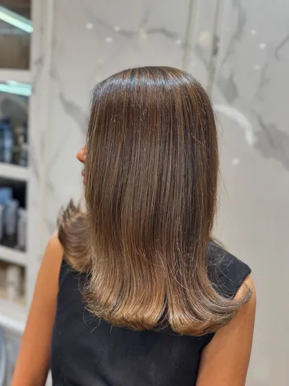 The side profile shows how the balayage adds dimension even to straight hair.