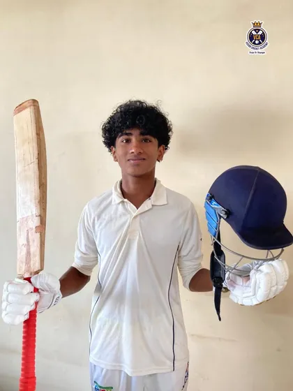 A fantastic all-round display. Shamik Shettigar, in his cricket whites, holds his bat and helmet after scoring 98 runs and taking 2 wickets for his school in a Harris Shield fourth-round match.