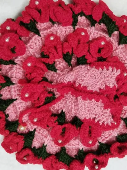 I love working on detailed floral designs like this one. This poshak features layers of red crochet flowers on a soft pink base, with small pearls scattered throughout, creating a beautiful garden-like effect.