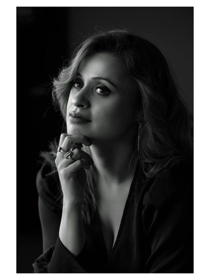 A classic black and white portrait with dramatic lighting. The model's expression is intense and captivating.