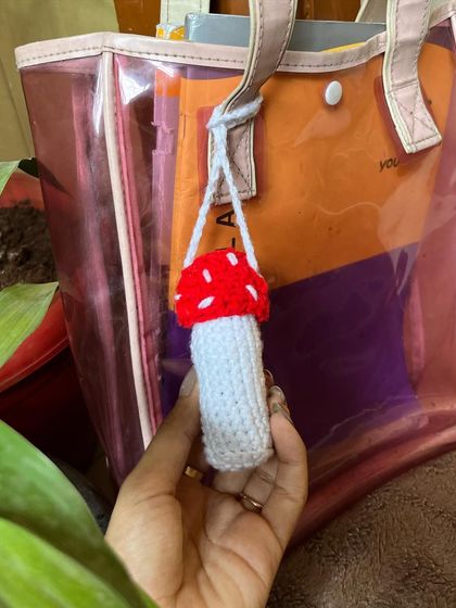 A close-up shot of the mushroom lip balm holder, highlighting the stitched details.