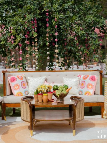 A cozy seating nook at the 'Gulbahar' celebration, with custom-printed cushions and a tree adorned with floral hangings. The design took you back to memories of sweet old Rajasthan.