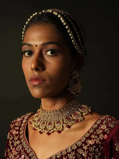 A clear portrait showing the makeup on a deeper skin tone. The look is natural and enhancing, with a focus on skin-like finish and subtle definition.