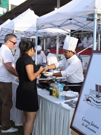 Service with a smile is our guarantee. Here is one of our professional chefs serving a freshly prepared pasta dish at a VIP lounge event at the Mahalaxmi Racecourse. We ensure your guests feel welcomed and well-cared for.