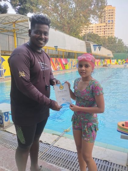 A student at our BKC branch is recognized for her hard work and dedication, receiving her certificate of completion from her coach.