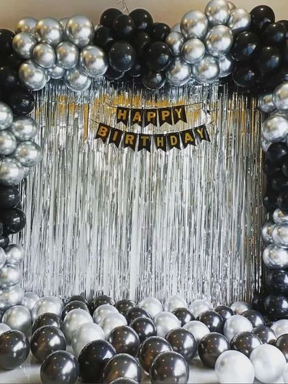A classic black and silver balloon arch over a silver shimmer curtain. This is a simple yet very effective way to create a stylish photo backdrop at home.