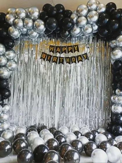 A classic black and silver balloon arch over a silver shimmer curtain. This is a simple yet very effective way to create a stylish photo backdrop at home.