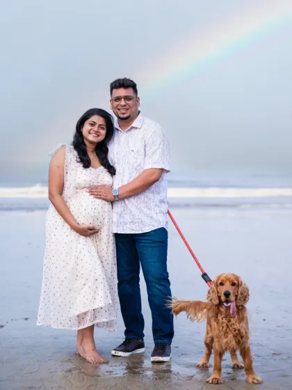 Sometimes, nature gives us a special gift. This beautiful family portrait, complete with their beloved dog and a surprise rainbow, makes for an unforgettable memory from their beach maternity photoshoot.