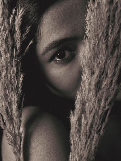 Peeking through the pampas grass, this shot is all about the eyes. The tight framing and the use of the prop as a natural vignette create a sense of intimacy and intrigue.