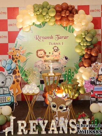 A playful safari adventure theme with animal cutouts in jeeps and a vibrant balloon arch. The setup is detailed with cactus props, light-up letters, and golden dessert stands for a fun and busy scene.