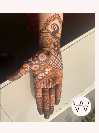 An Indian designer mehndi with peacock and kalash motifs.