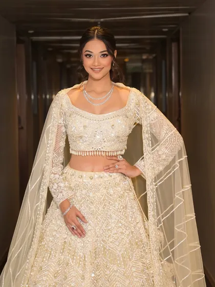 An angelic look for a Sangeet or reception. This client is wearing an all-white embellished lehenga, for which I created a soft glam look with glittery pink-toned eyes and a chic, textured ponytail.