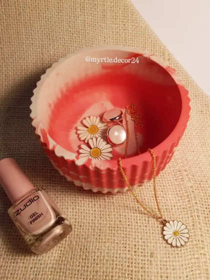 A custom-made marble round jar in a vibrant red and white pattern. This piece is perfect for storing jewelry and adds a bold pop of color to any vanity or dresser.