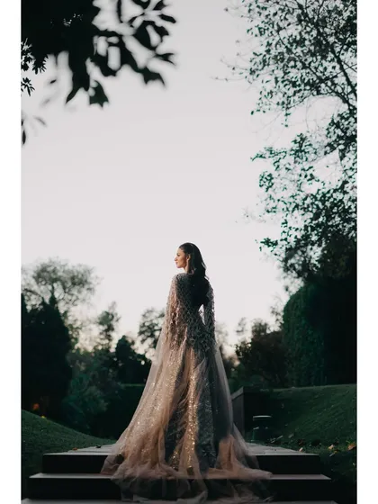 Every bride deserves a portrait that captures her grace and elegance. This shot, with its dramatic silhouette and the gown's flowing train against a natural backdrop, is a perfect example of our signature bridal portraiture.