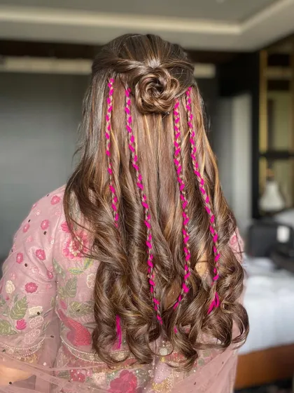 A back view of the fun carnival hairstyle, showing the intricate rose bun and the colorful braids woven through the curls.