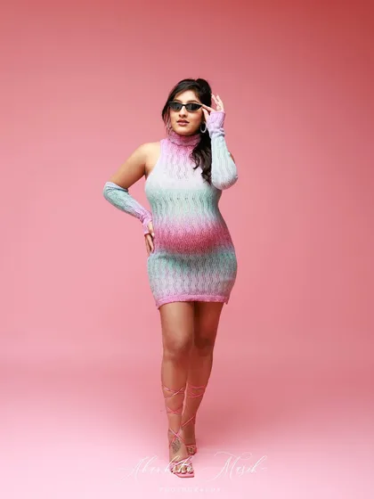 Strutting with style, this mom-to-be rocks a colorful knit dress and sunglasses for a fun, high-fashion Barbie-themed shot.