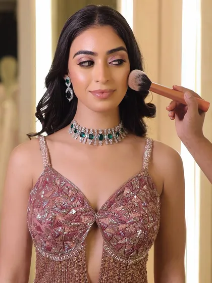 A behind-the-scenes moment, applying a touch of powder to set the look. This ensures the makeup stays flawless throughout the event.