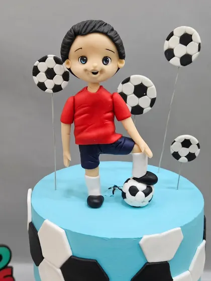 Another angle of the football anti-gravity cake, featuring the top figurine ready for action. Learning to create dynamic poses is key to making your cakes feel alive.