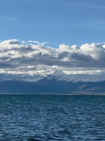 The deep blue expanse of Lake Mansarovar under a sky full of clouds, with the Himalayan range in the distance. This is a landscape that silences the mind.