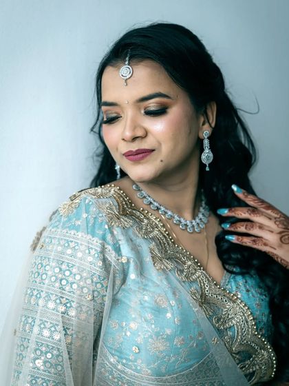 A close up portrait focusing on the bride-to-be's makeup, hair, and the delicate details of her outfit.