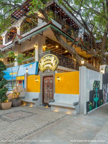 The entrance to Adda 1522, with its traditional wooden door and bright yellow wall. The design immediately establishes a nostalgic and welcoming vibe, inviting guests into a different era.
