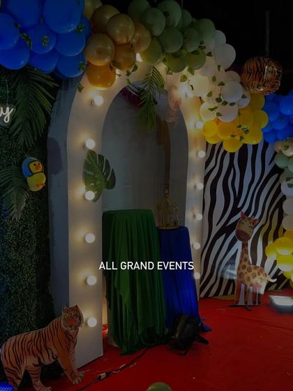A closer look at the jungle stage details, featuring a tiger, giraffe, and a neon 'Happy Birthday' sign against a green foliage backdrop.