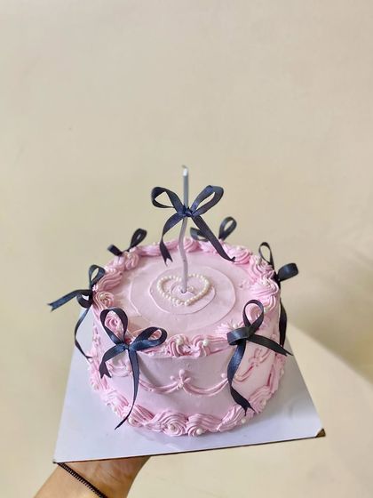 A different angle of our trendy pink cake with black bows.